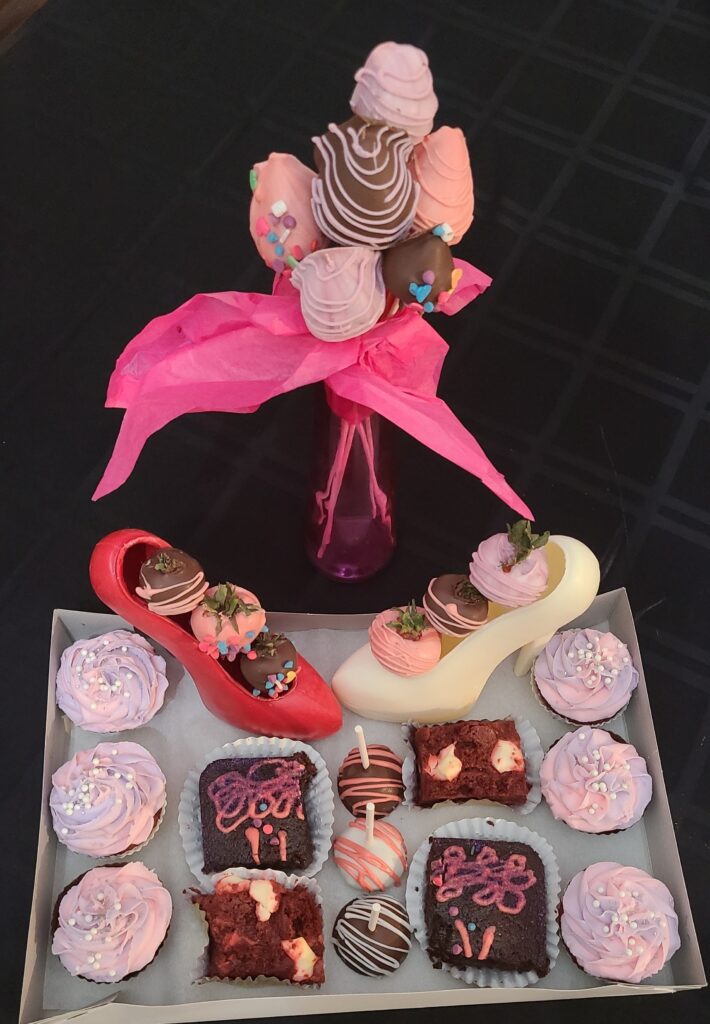 Pink chocolate high heel with decorated desserts and confections
