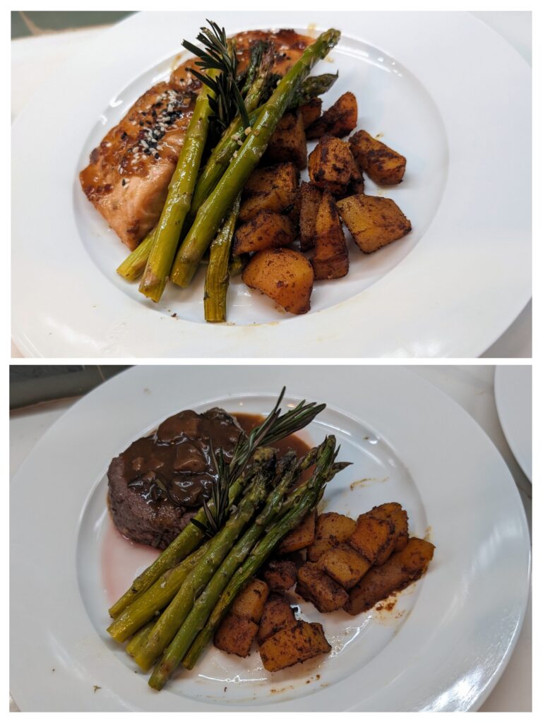 Two plated steak dinners with asparagus and roasted vegetables
